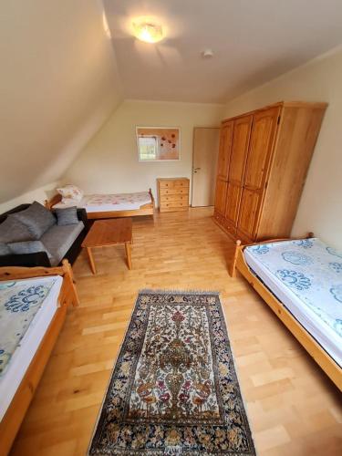 a living room with two beds and a rug at Ferienwohnungen Pöttker in Bad Zwischenahn