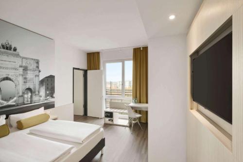 a hotel room with a large flat screen tv at Super 8 by Wyndham Munich City West in Munich