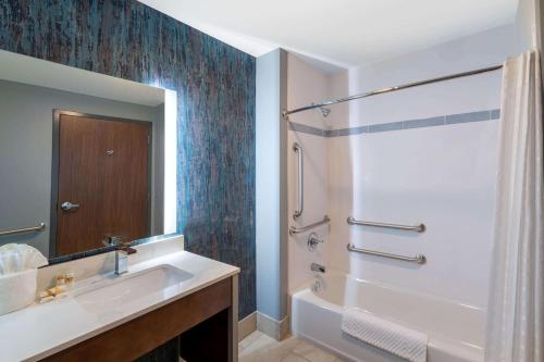 a bathroom with a tub and a sink and a shower at La Quinta Inn & Suites by Wyndham Louisville NE - Old Henry Rd in Louisville
