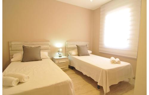 カネット・デ・マールにあるHomeHolidaysRentals Canet Playa Iのベッドルーム1室(ベッド2台、タオル付)