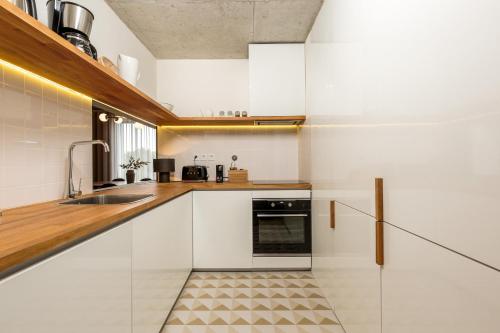 a kitchen with white cabinets and a sink at Feel Porto Corporate Housing Campanhã in Porto