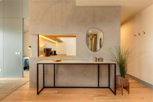 ein Wohnzimmer mit einem Tisch und einem Spiegel in der Unterkunft Feel Porto Corporate Housing Campanhã in Porto