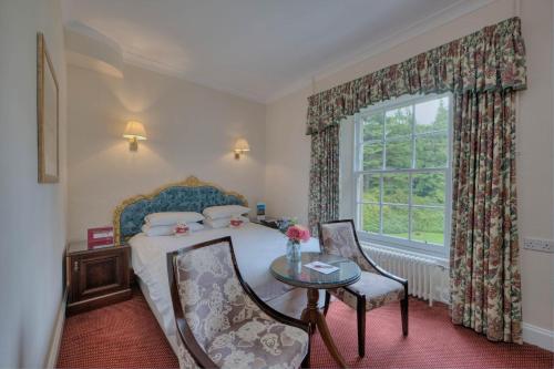 a bedroom with a bed and a table and a window at Muthu Newton Hotel (Near Inverness Airport) in Nairn