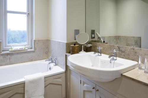 a white bathroom with a sink and a mirror at The Bath Priory - A Relais & Chateaux Hotel in Bath