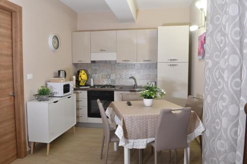 cocina con mesa y cocina con armarios blancos en Casa Marconi Ribera, en Ribera