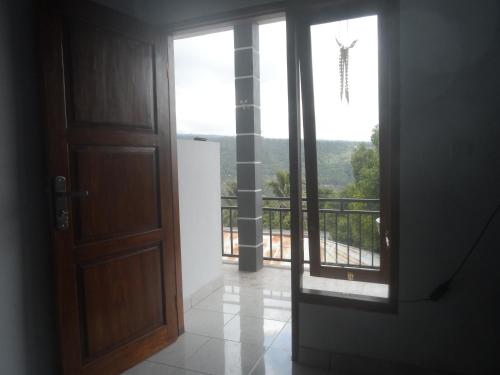 an open door with a view of a balcony at One Homestay and Warung in Munduk