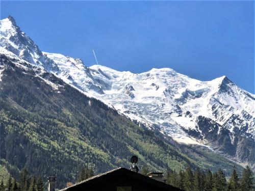 une montagne enneigée avec une maison en face dans l'établissement Chamonix superbe appartement vue Mont Blanc, à Chamonix-Mont-Blanc