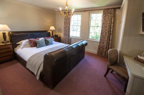 a bedroom with a large bed with a leather headboard at The Bath Priory - A Relais & Chateaux Hotel in Bath