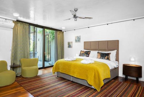1 dormitorio con 1 cama grande con manta amarilla en Montreux Rotana Garden House with Private Pool - Swiss Hotel Apartments, en Montreux