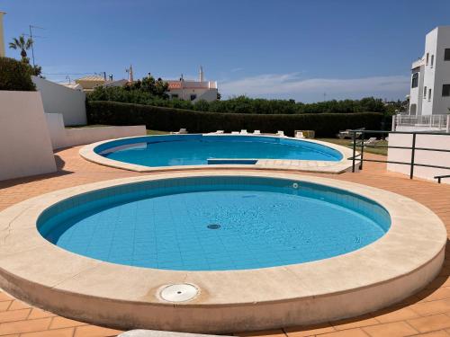 uma grande piscina com água azul num pátio em Casa As Estrelas em Carvoeiro