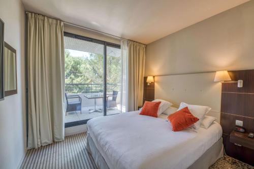 um quarto de hotel com uma cama e uma varanda em Hôtel de l'Arbois em Aix-en-Provence