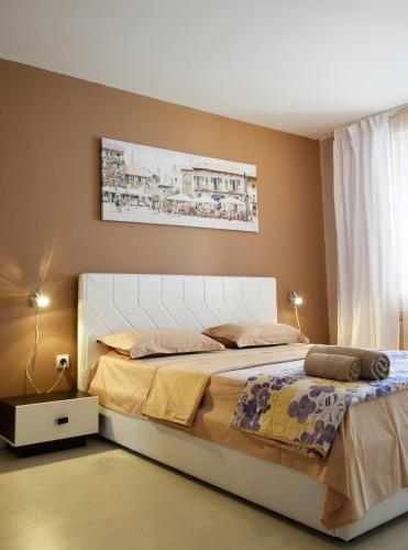 a bedroom with a large bed with a white headboard at dream apartment in Obzor