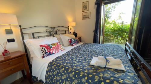 a bedroom with a bed with a blue and white comforter at Agriturismo La Casa Del Ghiro in Pimonte