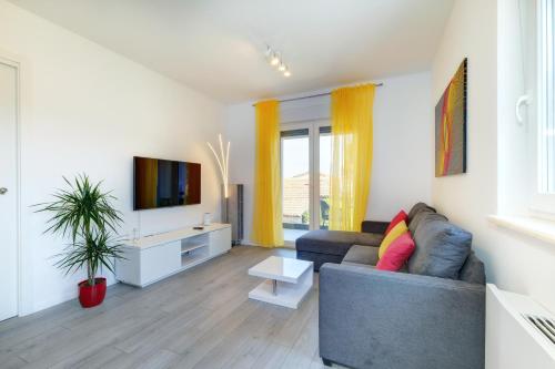 ein Wohnzimmer mit einem Sofa und einem TV in der Unterkunft Apartments Hemetek in Veli Lošinj