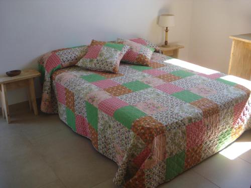 a bed with a quilt on it in a room at Villa Romaní SUITE in Son Carrio