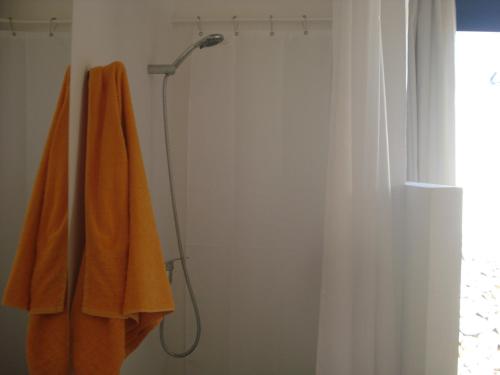 Villa Romaní SUITE في Son Carrio: منشفة برتقالية معلقة في الحمام
