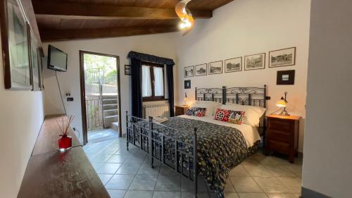 a bedroom with a black bed in a room at Agriturismo La Casa Del Ghiro in Pimonte