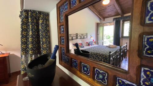 a bedroom with a mirror and a bed in a room at Agriturismo La Casa Del Ghiro in Pimonte
