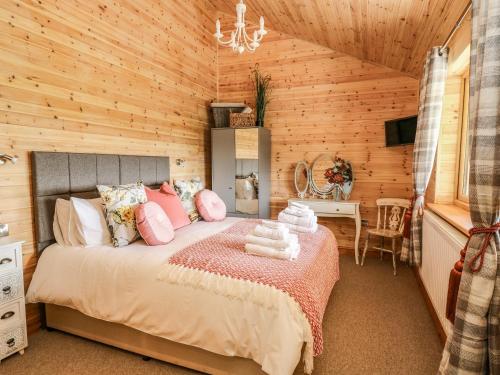 a bedroom with a bed in a wooden room at The Larches in Llanidloes