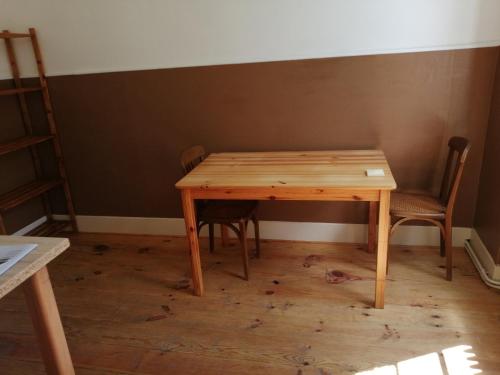 - une table en bois et 2 chaises dans une chambre dans l'établissement MAISON ALBA LA SOURCE, à Mazamet