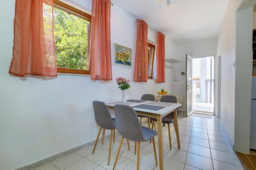 a dining room with a table and chairs at Apartments Hemetek in Veli Lošinj