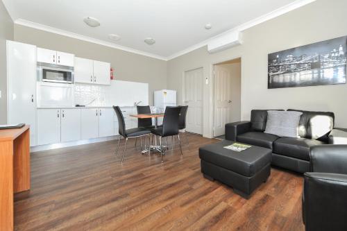 a living room with a couch and a table at Akuna Motor Inn and Apartments in Dubbo