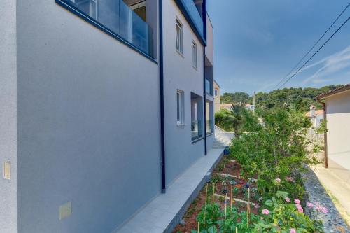 a side view of a building with a garden at Apartments Hemetek in Veli Lošinj