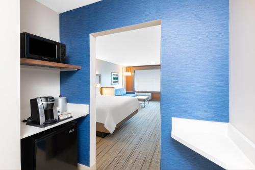 a hotel room with a bed and a mirror at Holiday Inn Express & Suites - Phoenix - Airport North by IHG in Phoenix