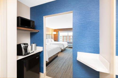a hotel room with two beds and a mirror at Holiday Inn Express & Suites - Phoenix - Airport North by IHG in Phoenix