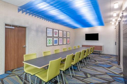 a conference room with a long table and yellow chairs at Holiday Inn Express & Suites - Phoenix - Airport North by IHG in Phoenix