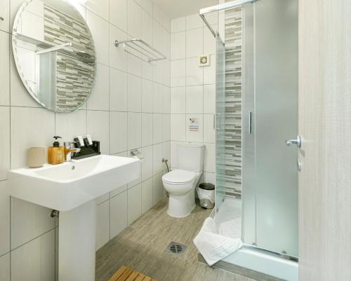 y baño con lavabo, aseo y espejo. en Dedis Apartment's en Neos Marmaras