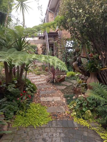 a garden with a stone walkway in front of a building at Troas Boutique hotel in Vanderbijlpark