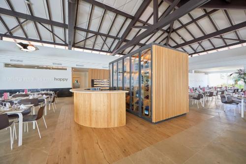 een restaurant met een bar, tafels en stoelen bij Prinsotel La Dorada & Spa in Playa de Muro