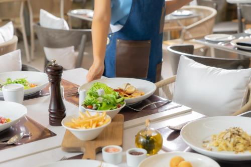 a table with plates of food on it at Bayphere Hotel Pattaya JC in Na Jomtien