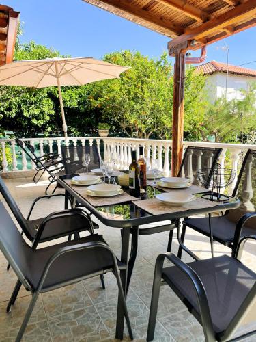 a table with chairs and an umbrella on a patio at Casa Lia-Beach Front Villa in Nea Kalikratia