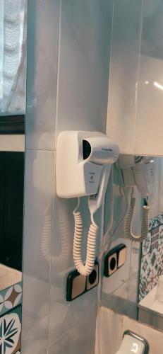 a bathroom with a hair dryer and a phone on the wall at Pensión Nigrán in Nigrán