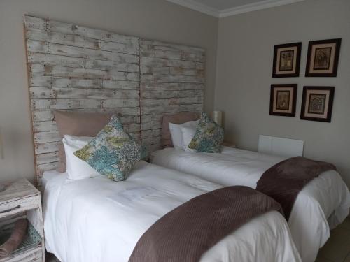 two beds sitting next to each other in a bedroom at Troas Boutique hotel in Vanderbijlpark