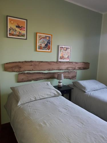 a bedroom with two beds and a wooden headboard at Le Briccole in Collegno