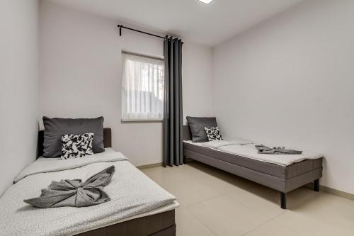 a bedroom with two beds and a window at Zielone Apartamenty Katowice Chorzów in Chorzów