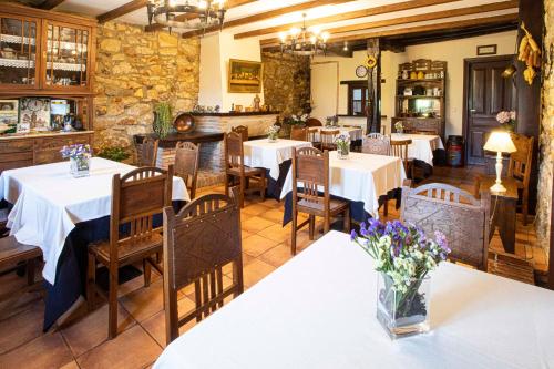 a restaurant with tables and chairs with flowers on them at La Casona de Tresgrandas in Tresgrandas