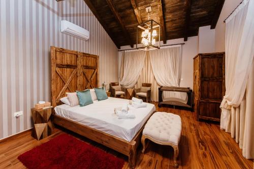 a bedroom with a large bed with a red rug at Grand Mansion Countryhouse & Spa in Phrenaros