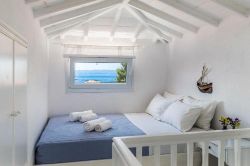 a white room with a bed and a window at Milia Beach Apartments in Paralia Milia