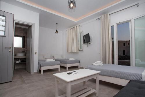 a hotel room with two beds and a table at Phoenix studios in Mikonos