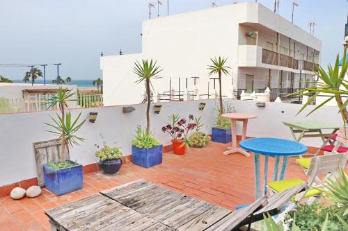 eine Terrasse mit einem Tisch, Stühlen und Pflanzen in der Unterkunft Habitación Cañaveral Playa Conil I in Conil de la Frontera