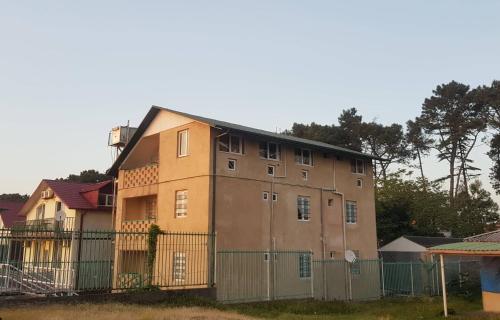 a large building with a fence in front of it at Ureki House in Ureki