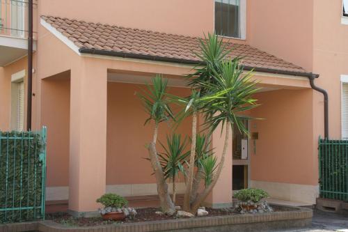 a house with two palm trees in front of it at Residence Mizar in Pietra Ligure