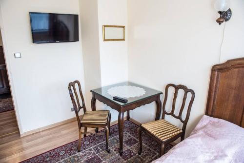 a small table and chairs in a room with a bed at Noclegi u Ewy in Witów