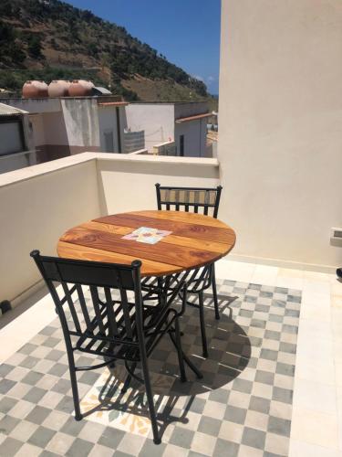 a wooden table and two chairs on a roof at Casa Colore Attic in Castellammare del Golfo