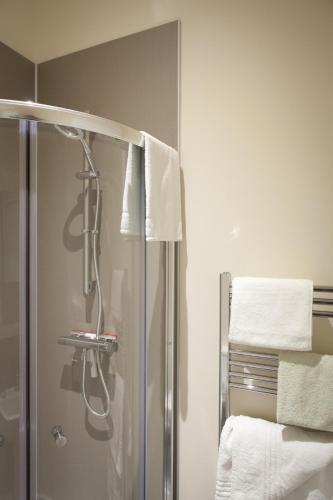 a shower in a bathroom with towels on the wall at Toothbrush Apartments - Ipswich Central East in Ipswich