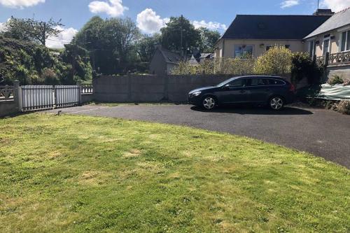 une voiture noire garée dans l'allée d'une maison dans l'établissement Charmante maison rénovée Proche plage,port,clos, à Lézardrieux